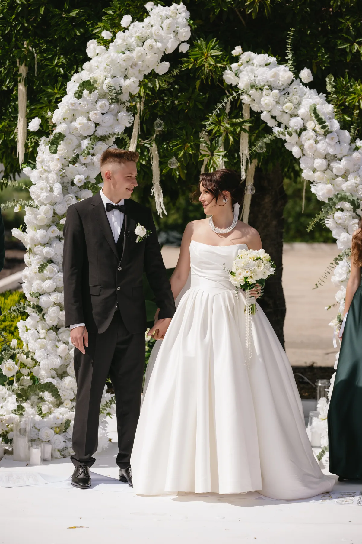 Noivos sob um arco floral branco no Xarme